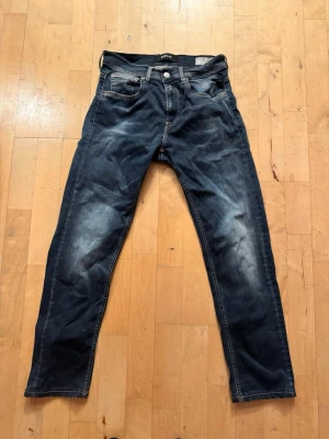 Replay jeans Grover - Snygga mörkblå jeans från Replay med klassisk femficksdesign och diskreta slitningar framtill och baktill. Jeansen har raka ben och tydliga kontrastsömmar. Tillverkade i denim med en cool tvättad look. Grover modell, storlek 28