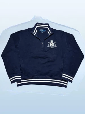 Vintage Ralph Lauren 1/4 zip tröja - herr strl L - Säljer en Vintage Ralph Lauren 1/4 zip tröja i mörkmarinblå färg med vita detaljer i storlek L med broderi på vänster sida av bröstkorgen.  👕 Märke: Ralph Lauren 📏 Storlek: L 🎨 Färg: Mörkmarinblå med vita detaljer 🧵 Material: 100% bomull 📐 Mått: 65 cm lång, 62 cm bred 📌 Skick: Mycket bra skick (se bilder)  💬 Hör av dig vid frågor 💰 Pris kan diskuteras vid snabb affär 📦 Skickas inom 24 timmar