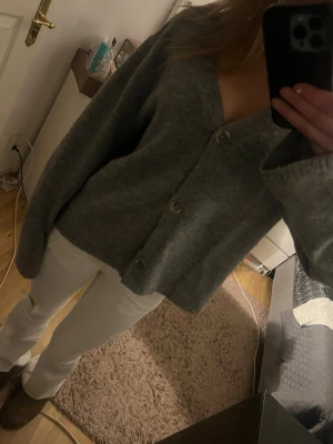 Grå kofta med knappar från lager 157 - Mysig grå kofta från lager 157 med v-ringning och tre stora knappar framtill. Koftan har en avslappnad passform, långa ärmar och är stickad i ett mjukt material. Perfekt att slänga över en topp för en chill look.