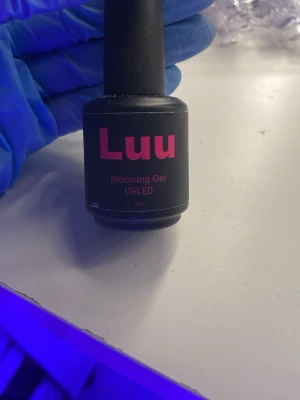 Luu Blooming Gel UV/LED 15ml - Luu Blooming Gel är ett genomskinligt gel för naglar som används för att skapa unika marmor- och blomningseffekter. Passar UV/LED-lampa och kommer i en svart flaska med rosa text. Innehåller 15 ml.