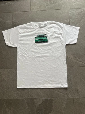 Vit premium t-shirt med grön BMW tryck - Tjena jag säljer denna feeta tshirt!  Tröjan är  en vit tshirt storlek Ⓜ️  100% bomull 🧶  helt ny, aldrig använd🆕  Mått 📏 67cm lång från axel 49 cm bred vid magen 34 cm lång från hals till ärmslut 47cm bred i axlarna.                                                                              /                                                                                                   Skriv om du undrar något så löser vi det!😊