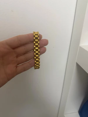 Guldigt länkarmband i metall - Snyggt armband i guldfärgad metall med breda länkar och en stilren, modern design.