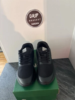 Svarta Lacoste sneakers i mesh och skinn - helt nya och oanvända stilrena svarta sneakers från Lacoste i storlek 44 köpt på lacoste hemsida för 1200 kr. skorna är ovandel i mesh och detaljer i skinn. Klassisk låg modell med snörning och den ikoniska krokodilloggan på sidan. Perfekta för en clean och sportig look.
