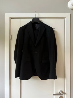 Svart kostym perfekt till bal & student - Helt ny svart komplett kostym från Brothers. Använts vid ett tillfälle. Nypris 3399kr. Säljer den nu för endast 800kr. Storlek 46 både i byxor och kavaj. Perfekt till bal & student. Skriv vid frågor!