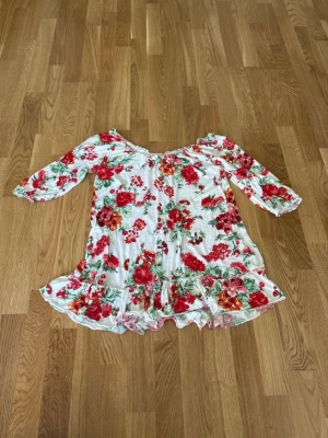 Topp Gina Tricot stl S - Blommig volangtopp från Gina Tricot i storlek S.  Kan bäras off shoulder eller som den är.  Trekvartsärmar.  Mycket bra skick och bekvämt material. 