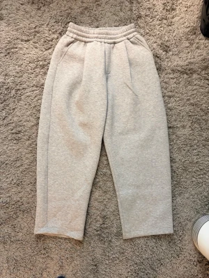 Grå mjukisbyxor från Bershka - Säljer ett par grå mjukisbyxor från Bershka i storlek XS. Byxorna har resår i midjan, raka ben och sidofickor. Tillverkade i mjukt sweatshirtmaterial som är perfekt för chill dagar. Enkel och clean design som passar till det mesta.
