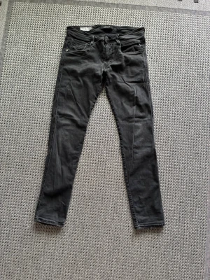 Svarta slim fit jeans från Replay - Säljer ett par svarta slim fit jeans från Replay,  Jeansen har klassisk femficksdesign, normal midja och smala ben. Materialet är mjukt och stretchigt för extra komfort. Perfekta till en avslappnad grischig stil. 