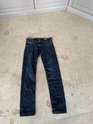 Mörkblåa Replay Jeans - Snygga mörkblå Replay Jeans. Bra passform och klassisk femficksdesign. Jeansen har en enkel look utan slitningar och är tillverkade i ett denimtyg med lätt stretch. Perfekta för en stilren vardagsoutfit.