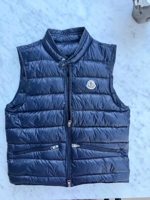 Mörkblå dunväst från Moncler - Väldigt bra skick, använts ett få tall gånger. Perfekt för sommaren. Storlek S 
