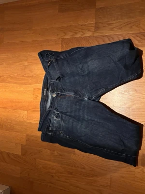 Mörkblå raka jeans från Replay - Snygga mörkblå jeans från Replay med klassisk femficksdesign och raka ben. Jeansen har en diskret tvätt och detaljerade sömmar. Defekt vid skrevet som syns bättre på bild tre men går att fixa. Storlek 29/32. Skriv vid funderingar 