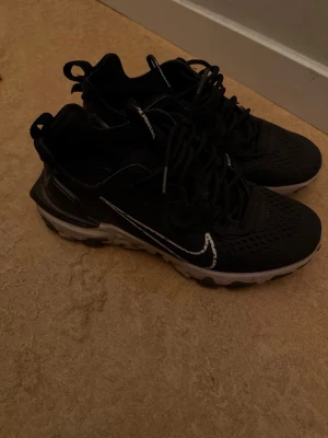 Nike Air Max svartvita sneakers - Svarta Nike Air Max sneakers med vit sula och vit swoosh-logga på sidan. Ovandelen är i mesh för bra andningsförmåga och skon har synlig Air Max-dämpning i sulan. Klassisk snörning och sportig look som passar till streetwear.