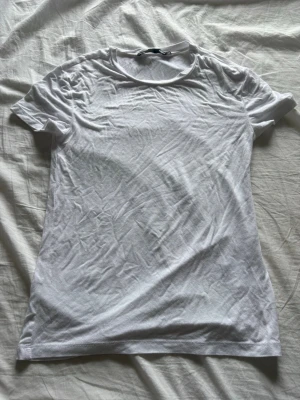 Vit basic t-shirt från 157 - Klassisk vit t-shirt från 157 i storlek XS. T-shirten har rund halsringning och korta ärmar. Tillverkad i mjuk bomull som känns skön mot huden. Perfekt att matcha med jeans eller shorts för en enkel och clean look.