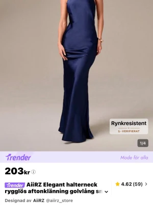Marinblå långklänning från AiiRZ - Snygg marinblå långklänning från AiiRZ med halterneck och öppen rygg. Klänningen har en elegant, figurnära passform och är tillverkad i ett glansigt material som ger en lyxig känsla. Perfekt för dig som vill sticka ut på festen.