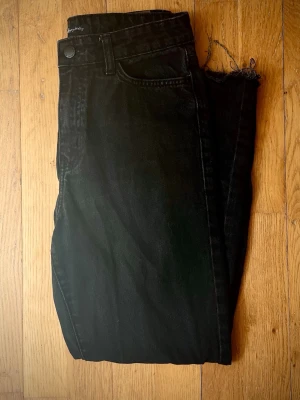 Straight jeans high waisted - Jeans från Happy Holly (Bubbleroom). Högmidjade jeans med fem fickor och hällor för bälte. Modellen har raka ben med fransiga detaljer. Gylf med dragkedja och knapp i metall framtill. Innerbenslängd: 66 cm.