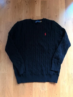 Svart kabelstickad tröja Polo Ralph Lauren - Garderoben färdig rensad och säljer denna schyssta polo Ralph lauren knitten. Vet att sommar tränger sig långsamt in runt hörnet, men aldrig försent för att skönt Ralph lauren plagg. Kan diskutera pris, svarar snabbt på frågor!!
