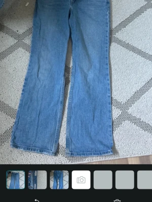 Blå bootcut jeans low rise - Säljer ett par ljusblå bootcut jeans med låg midja. Vida och utsvängda ben. Perfekta för dig som gillar retrovibbar och avslappnad stil. Märkning 'LOW PATCHBOOT' i midjan.