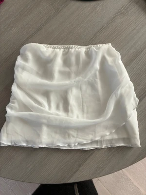 Vit supersnygg kortare kjol - Säljer en vit kortkjol. Den har dragkjedja i bak och stretchig midja som gör kjolen lätt att sätta på sig men samtidigt en figursydd look när den är på. Perfekt för sommarens alla outfits! Inga prislapp kvar men aldrig använd då den tyvärr är för liten.