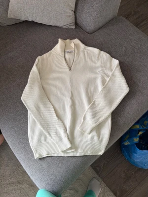 Zara stickad tröja med dragkedja | M | Off-white - Säljer en stilren stickad tröja från Zara i off-white/cream.  ▫️ Storlek: M ▫️ Hög krage med dragkedja ▫️ Tjock och skön stickning ▫️ Enkel att matcha med både jeans och kostymbyxor ▫️ Fint skick  En klassisk och tidlös modell som fungerar året runt.  📏 Skickar gärna mått vid intresse.  📸 Fler bilder, närbilder och passformsbilder skickas gärna om så önskas.                                      💬 Hör av dig vid frågor eller intresse.