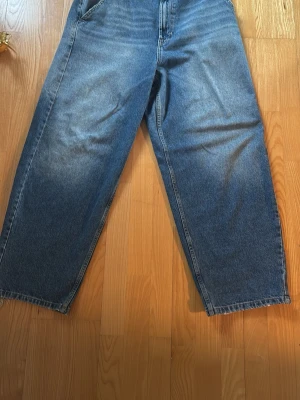 Bershka jeans  - Säljer ett par blåa jeans med rak passform . Jeansen har klassisk femficksdesign framtill och två stora bakfickor. Materialet är kraftig denim i 100% bomull och benen är vida hela vägen ner.