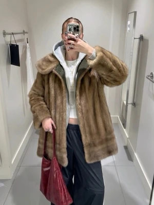 Brun vintage pälsjacka - Säljer en klassisk oversized pälsjacka i vintage-stil med bred krage och rak passform. Jackan har en mjuk, lyxig känsla och är fodrad med rosa tyg på insidan. 
