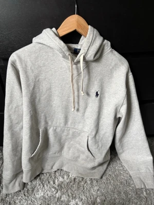 Grå hoodie från Polo Ralph Lauren som passar S - Snygg grå hoodie från Polo Ralph Lauren med klassisk huva och dragsnören. Den är i väldigt gott skick och har inga skador, pris kan diskuteras. Den passar S. Hör av er vid frågor!