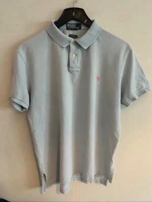 Polo Ralph Lauren piké - • 🇸🇪 Ljusblå Piké från Polo Ralph Lauren. Broderad logga på bröstet.   Använd, men fortfarande i fräscht skick utan några speciella anmärkningar.   Pris går alltid att diskutera vid snabb affär 🥂 