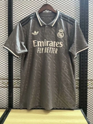 Grå Real Madrid träningströja Adidas - Snygg grå träningströja från Adidas x Real Madrid med vita detaljer och klubbmärke på bröstet. Tröjan har krage med knapp, korta ärmar och diskret mönster i tyget. Perfekt för fotbollsträning eller som supporterplagg.