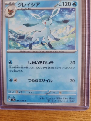 Pokémonkort Glaceon japansk - Japanskt Pokémonkort med Glaceon-motiv, blå och vit design med isigt landskap i bakgrunden. Kortet har tydliga japanska tecken och är inplastat i ett genomskinligt plastfodral. Perfekt för samlare av Pokémonkort eller fans av Glaceon.