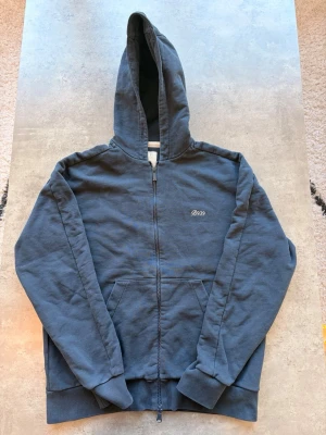 Boggi Milano hoodie - Mörkblå hoodie med dragkedja från Boggi Milano. Klassisk modell med huva, fickor och ribbade muddar vid ärmslut och nederkant. Perfekt för sommaren och enkel att matcha med jeans eller joggers