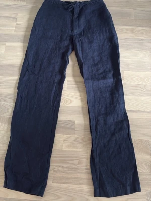 Blåa Linnebyxor - Linnebyxor i bra skick, har ryckt lappen så vet inte riktigt storleken men sitter bra på mig är 178, 74kg. Antar runt M, skön bootcut längst ner så de lägger sig fint över skorna.