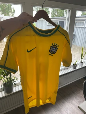 Brasilien Ronaldo 9 fotbollströja Nike - Pris kan diskuteras. Gul Brasilien fotbollströja från Nike med gröna detaljer, officiellt landslagsmärke och nummer 9 samt Ronaldo på ryggen. Helt ny, använt 1 gång och finns ingen speciell anledning till att jag vill sälja. 