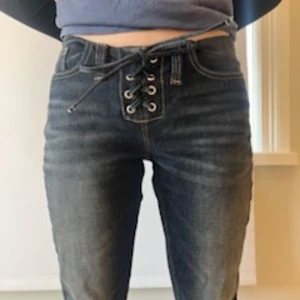 Mörkblå snörade jeans med låg midja  - Säljer ett par mörkblå jeans med låg midja och cool snörning framtill istället för vanlig dragkedja. Knappt använda, bara att skriva vid mått eller bilder 💞säljer eftersom dem inte kommer till användning 