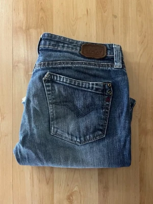 Replay jeans  - Säljer ett par blå Replay jeans. Midja 36cm, längd 79cm. OBS att jeansens benslut är avklippta, därav är L storlek INTE 32. Utan jag bedömer dem till L26 men utgå efter mått.  Ifall det inte finns någon bild i annonsen där jag bär plaggen jag säljer så är det för att jag ej kan ha storleken heller passformen, så kolla måtten för storlek och googla på modellnamnet för passform 😉 s6,1