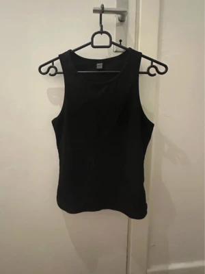 Svart ribbad linnetopp från SHEIN - Svart ribbad linne topp från shein i bra skick inte min stil längre! (Säljer även på vinted)