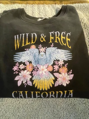 Sweatshirt  - En svart sweatshirt med tryck på. Är väldigt skön att ha på sig. Storlek=34-36 (XS-S)