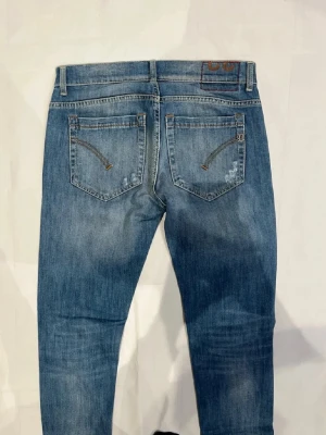 Blå jeans från Nudie Jeans - Ett par klassiska blå jeans från dondup med raka ben och normalhög midja. Jeansen har två bakfickor med dekorativa sömmar och en liten logotyp på höger ficka. Materialet är denim i bomull med lätt tvättad look. Om man vill va lite lyxigare än alla i mängden så är dom här jeansen perfekt för dig! OBS, möts bara upp i Stockholm skickar inte paket via postnord o så vidare😁