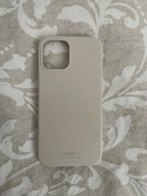 Sandfärgat mobilskal iPhone 12 från Holdit - Snyggt och stilrent mobilskal från Holdit i en mjuk beige färg. Skalet är gjort i ett flexibelt silikonmaterial som ger bra grepp och skydd till din mobil. 