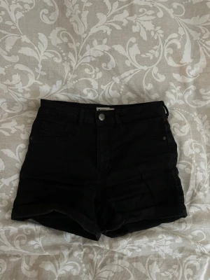 Svarta högmidjade jeansshorts - Snygga svarta högmidjade shorts i jeans material.