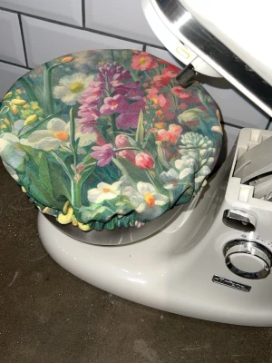 Bakmössa perfekt till jäsning  - Gör jäsningen både enklare och finare  Den här bakmössan är handsydd med omsorg och ersätter handduken när degen ska jäsa. Den träs smidigt över bunken och sitter kvar utan att glida.  Sydd i två lager tyg – enfärgad insida och mönstrad utsida, för en ombonad känsla och ett vackert uttryck i köket.  • Passar bunkar i standardmått 22–25 cm • Perfekt till KitchenAid-bunke • Fungerar även till springform • Återanvändbar och tvättbar  Oanvänd