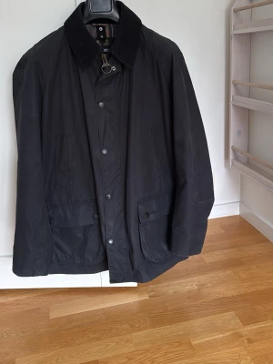Svart Barbour jacka  - Svart jacka från Barbour som är inköpt i London. Jackan används inte och säljs därför. Storleken är XL men passar även folk med storleken L.