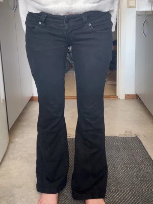 Svarta bootcut jeans från Abrand - Snygga svarta bootcut jeans från Abrand med låg midja och klassisk femficksmodell. Jeansen har utsvängda ben och är tillverkade i ett stretchigt bomullsmaterial för skön passform. Perfekta till en avslappnad och trendig look.