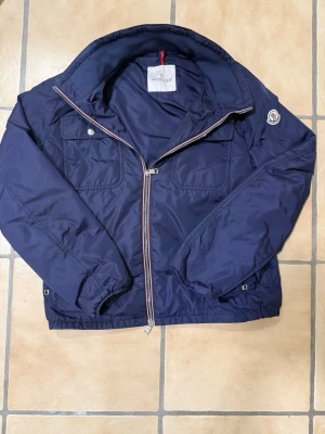 Moncler Windbreaker - Riktigt snygg moncler windbreaker köpt av fashion store och är såklart äkta. Ny pris är runt 8000kr och den är i väldigt bra skick. Den passar best mellan 175-180 men det går att ha om man är kortare eller lite längre. Storleken är 2 som är M men passar som S. Hör gärna av er vid frågor eller funderingar.