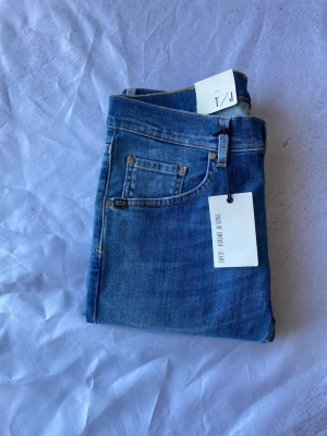 Blåa jeans från Tiger of Sweden-29/34 - Snygga blå jeans från Tiger of Sweden med klassisk femficksmodell och raka ben. Jeansen har gul kontrastsöm och är tillverkade i ett mjukt denimtyg. Perfekta för dig som gillar stilrena och tidlösa jeans. Nypris 1600 kr! Slim 