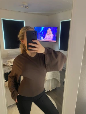Brun topp med vida ärmar - Säljer en brun topp med rund hals och riktigt vida, långa ärmar. Toppen har en enkel och stilren design. Materialet känns mjukt och bekvämt mot huden😊