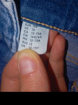 Ljusblå jeans från H&M, 12-13 år - Säljer ett par ljusblå jeans från H&M i storlek 12-13 år. Klassisk femficksmodell med kontrastsömmar och bälteshällor. Perfekta till vardagsstilen och lätta att matcha med olika toppar. Snygg och enkel design som alltid funkar.