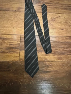 Svart grå slips från BOSS - Slips från boss I extremt bra skick tror jag använt den bara en gång! Inget är sönder alls. (Säljer även på vinted)