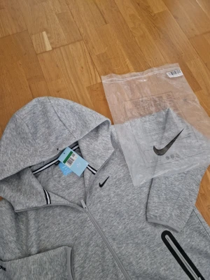 Grå Nike tech fleece från NOCTA - Säljer en helt ny nike tech fleece nocta! Storleken står XL men passar M!