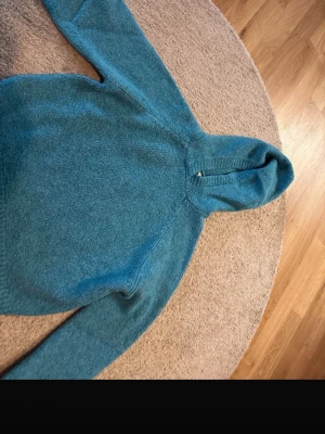 Blåmelerad hoodie i fleece - Mysig blåmelerad hoodie i mjuk fleece med huva och långa ärmar. Tröjan har en enkel, stilren design utan tryck eller fickor och är perfekt för dig som gillar en avslappnad look. Passar lika bra till jeans som till mjukisbyxor.