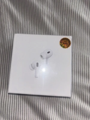  AirPods Pro - Säljer ett par vita Apple AirPods Pro (2nd generation) med MagSafe-laddningsetui och USB-C. Snygg och kompakt design i plast, perfekt för musik, poddar och samtal. Jag tror det är brusreducering men osäker. Köptes på Vinted för ett halvår sedan men aldrig använda pga att föräldrar köpte nya till mig istället. Säljs för samma pris som det köptes för! Vill få bort de så pris går absolut att diskutera 