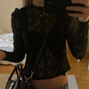 Svart spetsblus med volangdetaljer - Säljer en svart, långärmad spetsblus med volangdetaljer från hm🖤